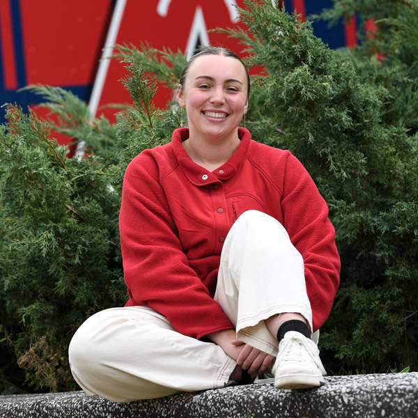 ASU President Sadie McAlear ('24) smiles in front of Wheelock Dining Hall